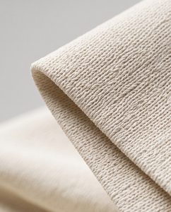 Close-up of folded 220 GSM heavyweight tee fabric showing substantial weight and crisp drape