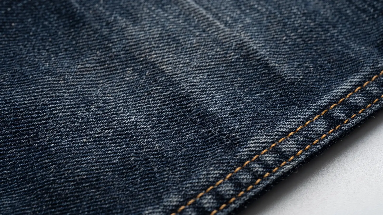 Close-up macro of denim fabric showing the twill weave and wash fade details
