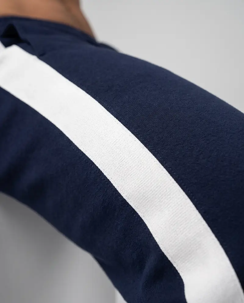 Close-up macro of retro track pants side stripes, showing webbing detail and fabric texture