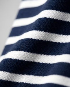Macro close-up of a navy-and-white striped heavyweight tee fabric, crisp horizontal stripes on a dense cotton weave