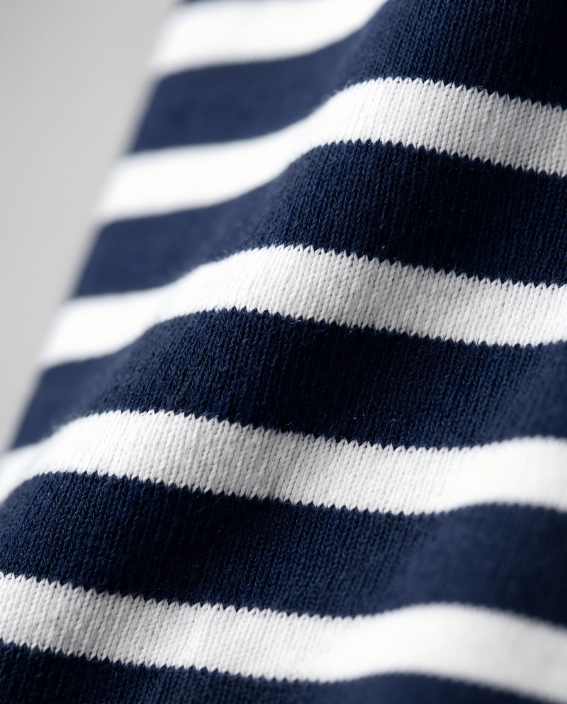 Macro close-up of a navy-and-white striped heavyweight tee fabric, crisp horizontal stripes on a dense cotton weave