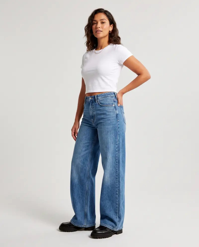 Full-body shot of a woman wearing wide-leg jeans with a cropped top and chunky shoes, retro-modern look