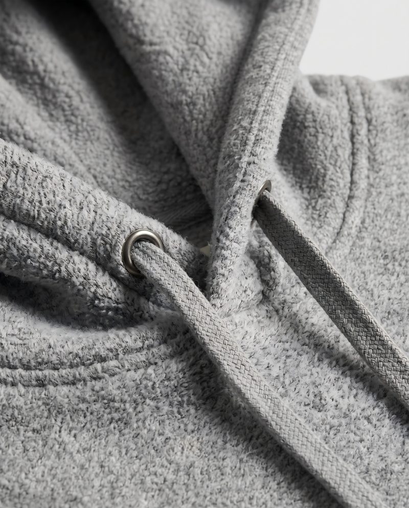 Close-up macro of a fleece hoodie showing the fabric and drawstring detail