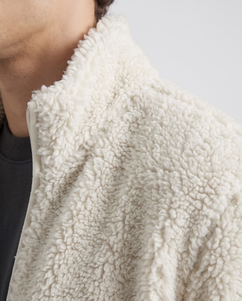 Close-up macro of a sherpa jacket showing the fluffy curly pile