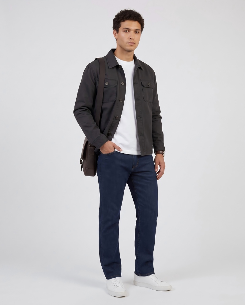Full-body shot of a male model wearing a work jacket with a tee and jeans, commuter look