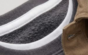 Close-up macro of a kids' cotton crewneck sweatshirt showing the soft fabric texture